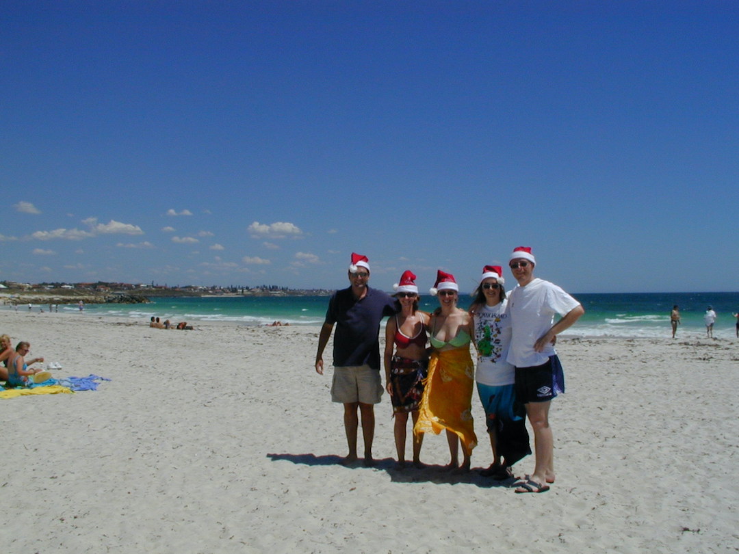 Dave and Sharon Schindler wearing Santa hats with friends on a beach in Perth Western Australia