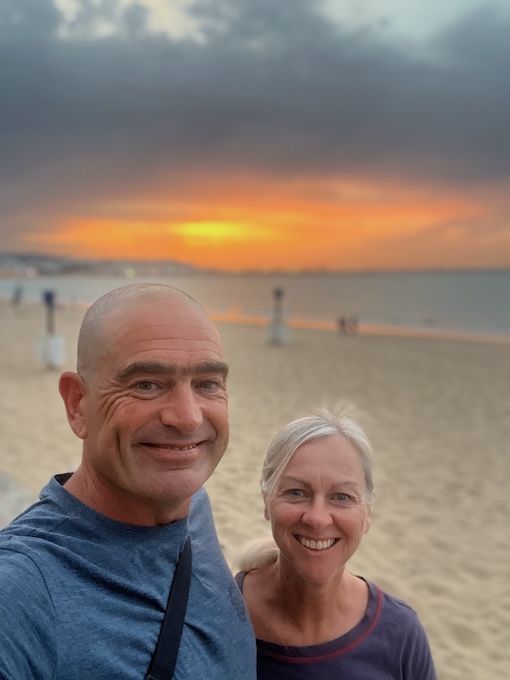 David and Sharon Schindler in front of the sunset on a beach in Tangier